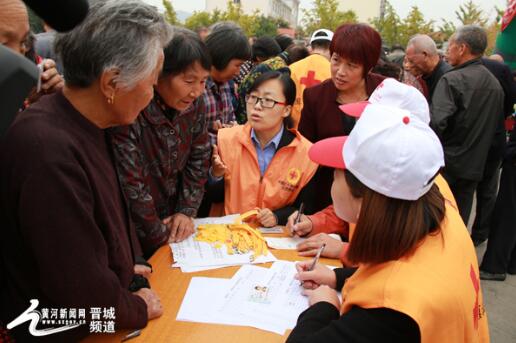 沁水縣市場(chǎng)監(jiān)管局龍港所執(zhí)法人員與紅十字志愿者給老人配帶黃手環(huán)